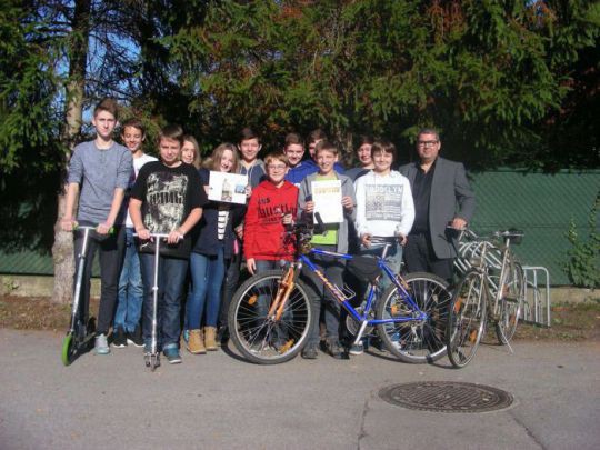 Gruppenfoto der Klasse 4a der NMS Pressbaum mit Scooter und Fahrrädern und Direktor