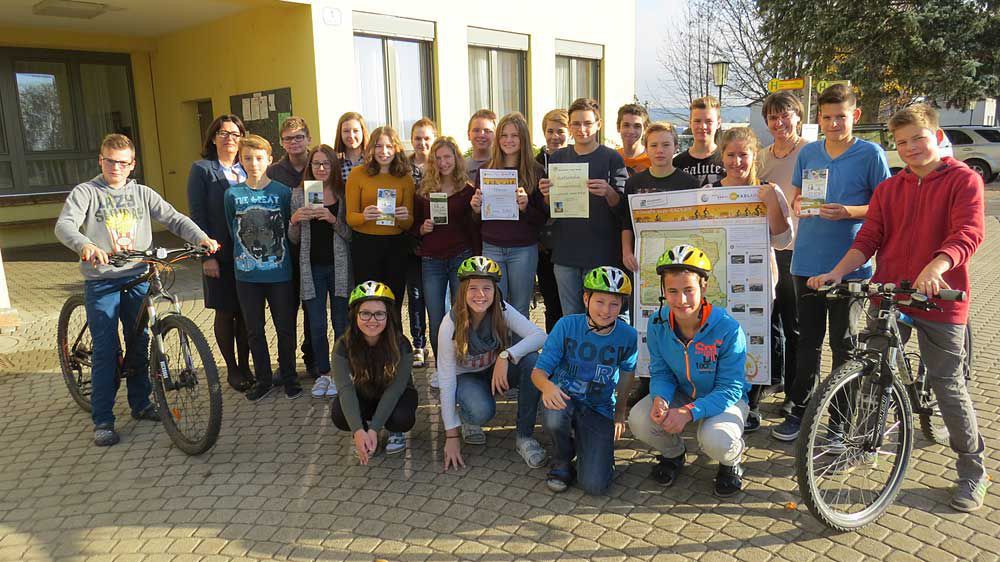 Die Klasse 4b der NMS Harmannsdorf vor ihrer Schule mit Fahrrädern, Radhelmen und "Klimafit zum RADLhit" - Urkunden (2015).
